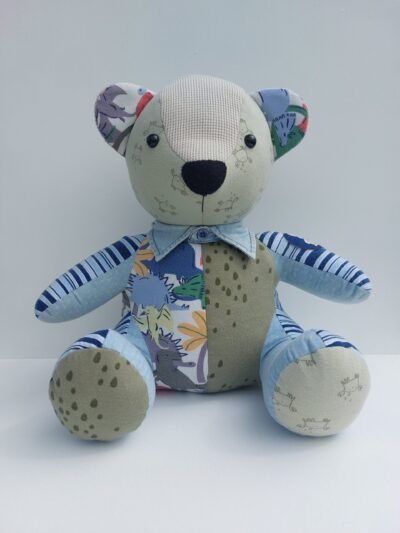 A Keepsake Memory Bear made from babies clothing in a sitting position looking very cute