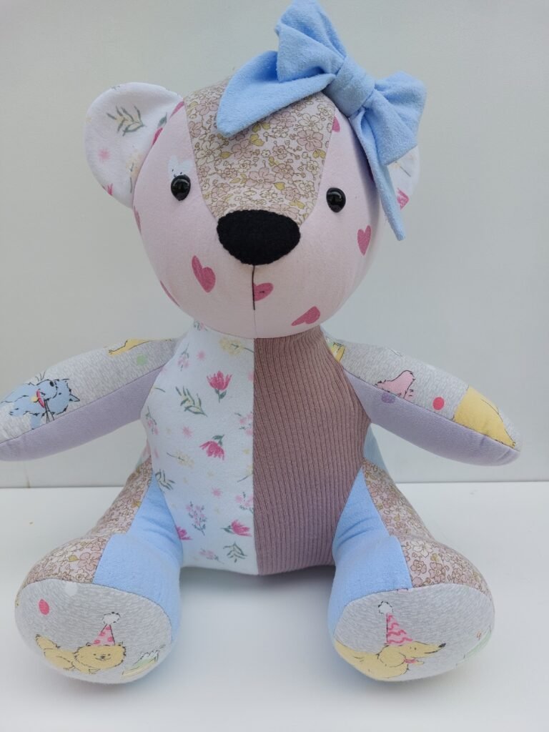 A sitting memory bear made from babies clothing