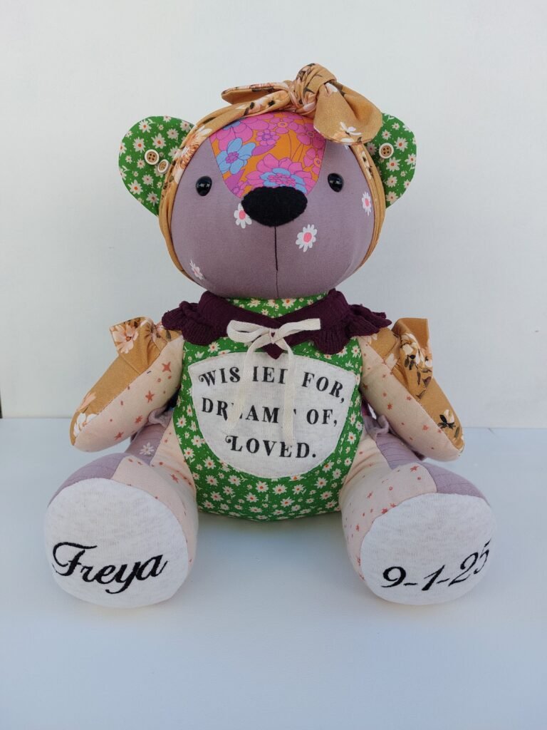 “Made from the tiny clothes she never got to outgrow — a bear to hold when your arms feel empty.”