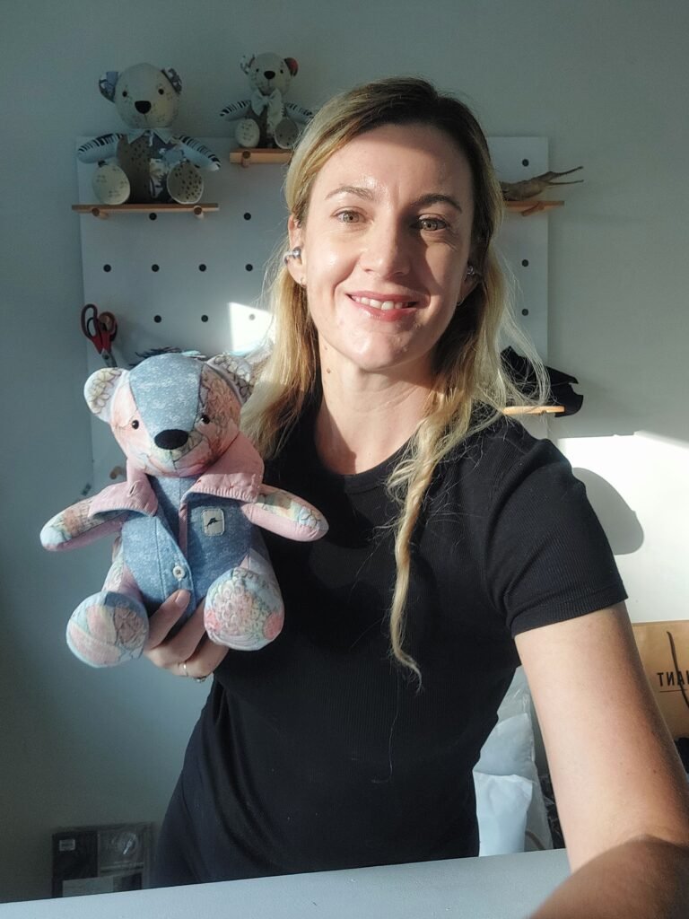 Woman holding a colorful teddy bear.